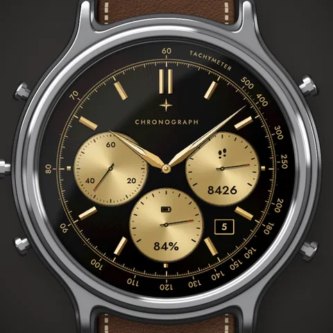 Astra Chrono Noir Zifferblatt für Garmin. Ein Chronograph in schwarzem Lack, der den ganzen Bildschirm füllt, mit goldenem Tachymeter auf dem Rehaut, drei großen Hilfszifferblättern und ohne Digitalzeit. Handgelenk heben, und der Chronograph startet.